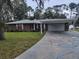 Single-story home featuring a covered carport with painted driveway and well-maintained lawn at 2215 Hontoon Rd., Deland, FL 32720