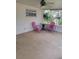 An enclosed patio area with a pair of pink chairs, a table, and neutral colored floor at 2215 Hontoon Rd., Deland, FL 32720