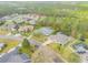 Aerial view of neighborhood featuring lush landscaping, mature trees and community pool at 27 Foxhunter Flt, Ormond Beach, FL 32174