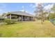 Fenced backyard with manicured lawn, mature trees and a screened-in porch at 27 Foxhunter Flt, Ormond Beach, FL 32174