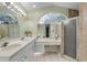 This bright bathroom features dual sinks, a vanity area, a walk-in shower, and bright neutral walls at 27 Foxhunter Flt, Ormond Beach, FL 32174