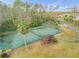 An aerial shot features well-maintained tennis courts with a gazebo, surrounded by trees and landscaping at 27 Foxhunter Flt, Ormond Beach, FL 32174