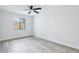The bedroom is bright with wood-look flooring, a ceiling fan, and a window overlooking the backyard at 305 Haverlake Cir, Apopka, FL 32712