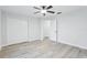 Bright bedroom featuring wood-look floors, a ceiling fan, double closets, and natural light at 305 Haverlake Cir, Apopka, FL 32712