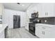 Kitchen with white cabinets, stainless steel appliances, and modern countertops at 305 Haverlake Cir, Apopka, FL 32712