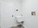 Functional laundry room featuring a utility sink and ample lighting at 305 Haverlake Cir, Apopka, FL 32712