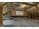 Unfinished attic with exposed insulation, wood beams, HVAC ducting and single window at 3450 Whitner Way, Sanford, FL 32773