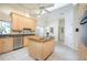 The kitchen features an island with a granite countertop, light wood cabinets, and stainless steel appliances at 398 Pine Tree Rd, Lake Mary, FL 32746