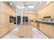This bright kitchen is equipped with light wood cabinets, recessed lighting, and an island with granite countertop at 398 Pine Tree Rd, Lake Mary, FL 32746