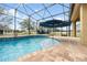 Gorgeous in-ground pool featuring a screened in enclosure and a relaxing umbrella covered seating area at 4160 Golden Willow Cir, Apopka, FL 32712