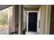 Apartment entrance featuring a black front door with an adjacent window on a small, private balcony with railing at 5016 Park Central Dr # 2231, Orlando, FL 32839