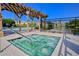 A bubbling community hot tub with pergola overlooks a pool and a tranquil lake with community buildings in the background at 5016 Park Central Dr # 2231, Orlando, FL 32839