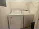 A bright laundry room features a white washing machine and dryer, and shelves for added storage at 5016 Park Central Dr # 2231, Orlando, FL 32839