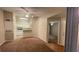 A living room opens to a kitchen with white appliances and brown carpet in a condo for sale at 5016 Park Central Dr # 2231, Orlando, FL 32839