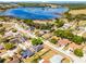 This aerial view of the neighborhood displays a lake and houses with pools at 525 Gentle Breeze Dr, Minneola, FL 34715