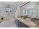 A full bathroom with a soaking tub, double vanity, and framed mirror at 525 Gentle Breeze Dr, Minneola, FL 34715
