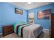 A colorful bedroom featuring an art collection, ceiling fan, and neutral carpeting at 525 Gentle Breeze Dr, Minneola, FL 34715