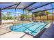 This screened-in pool and hot tub are surrounded by a concrete deck and white fencing at 525 Gentle Breeze Dr, Minneola, FL 34715