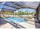 This screened-in pool features a connected hot tub and basketball hoop for outdoor enjoyment at 525 Gentle Breeze Dr, Minneola, FL 34715