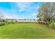 Spacious backyard featuring lush green grass and a tranquil view of the water, creating a serene outdoor space at 5380 Barton Dr, Orlando, FL 32807