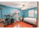 Bedroom with bright blue walls and floors, featuring a ceiling fan, two chairs, and natural lighting at 5380 Barton Dr, Orlando, FL 32807