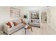 This stylish living room has tile flooring, comfortable seating, neutral tones and plenty of natural light from windows at 5509 Florence Harbor Dr, Orlando, FL 32829