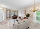 Bright living room with natural light, neutral-toned furniture, and tile flooring with a decorative chandelier overhead at 5509 Florence Harbor Dr, Orlando, FL 32829