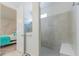 Modern tiled walk-in shower with seating adjacent to bright bedroom with accent wall decals at 5637 Cedar Chase Dr, St Cloud, FL 34771