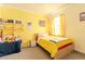 Cheerful bedroom with yellow walls, ample natural light and decorative shelves at 5637 Cedar Chase Dr, St Cloud, FL 34771