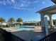 Community pool with palm trees, pool furniture and a view to the lake at 5637 Cedar Chase Dr, St Cloud, FL 34771