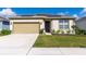 Charming one-story home with a beige exterior, well-manicured lawn, solar panels and an attached garage at 5637 Cedar Chase Dr, St Cloud, FL 34771