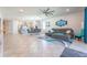 Spacious open concept living room with tile floors, gray sofa, and modern decor, open to dining area at 5637 Cedar Chase Dr, St Cloud, FL 34771