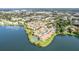 Aerial view of lakefront community featuring residential buildings and a tennis court at 586 Orange Dr # 114, Altamonte Springs, FL 32701