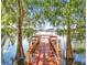 Picturesque wooden dock on the lake surrounded by cypress trees, creating a serene waterfront setting at 586 Orange Dr # 114, Altamonte Springs, FL 32701