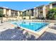 Community pool with sun loungers, tables and umbrellas in outdoor amenity space at 586 Orange Dr # 114, Altamonte Springs, FL 32701