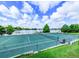 Scenic community tennis court overlooking a serene lake with lush greenery and blue skies at 586 Orange Dr # 114, Altamonte Springs, FL 32701