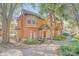 Attractive two-story townhome with manicured landscaping, a welcoming red front door, and a cozy front patio at 6356 Raleigh St # 1512, Orlando, FL 32835