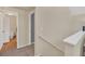 Upstairs hallway featuring neutral walls and trim, a light wood floor bathroom, and white railing at 6356 Raleigh St # 1512, Orlando, FL 32835