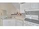 Clean kitchen features white cabinets, modern appliances, and an adjoining Gathering room at 6356 Raleigh St # 1512, Orlando, FL 32835