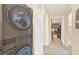 Laundry area with a stacked washer and dryer, and a view into a carpeted living space at 6356 Raleigh St # 1512, Orlando, FL 32835