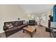 Comfortable living room featuring a plush leather sofa, a large center table, and lots of natural light from big windows at 6356 Raleigh St # 1512, Orlando, FL 32835