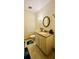Cozy bathroom with a vanity, granite countertop, round mirror, and tiled floors at 6429 Voltaire Dr, Orlando, FL 32809