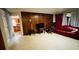 Living room featuring wood-paneled walls, a red leather couch, and natural lighting at 6429 Voltaire Dr, Orlando, FL 32809