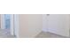 Hallway featuring neutral tile floor leading to carpeted rooms and white interior doors at 814 Massy Ct, Kissimmee, FL 34759
