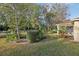 Beautiful backyard featuring mature trees, lush landscaping, and a screened-in porch, perfect for outdoor living at 820 Cypress Oak Cir, Deland, FL 32720