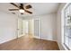 Cozy bedroom featuring wood-look tile floors, ceiling fan, and french doors at 820 Cypress Oak Cir, Deland, FL 32720