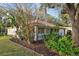Charming home exterior with a cozy front porch, complemented by beautiful landscaping and mature trees at 820 Cypress Oak Cir, Deland, FL 32720