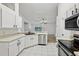 Bright white kitchen featuring stainless steel appliances and bar top at 820 Cypress Oak Cir, Deland, FL 32720