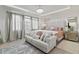 Bright primary bedroom featuring a decorative chandelier, accent wall, and large windows at 8515 Morehouse Dr, Orlando, FL 32836