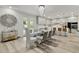 Bright dining room boasts modern chandelier, glass table, and patio access to the pool at 8515 Morehouse Dr, Orlando, FL 32836